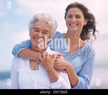 Eine Beziehung zu meiner mom aufzubauen. Porträt einer wunderschönen jungen Frau und ihrer Mutter am Strand. Stockfoto