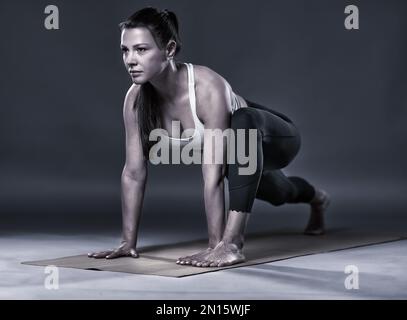 Einfarbig wie eine Trainerin in Yoga-Taubenposition (Kapotasana) Stockfoto