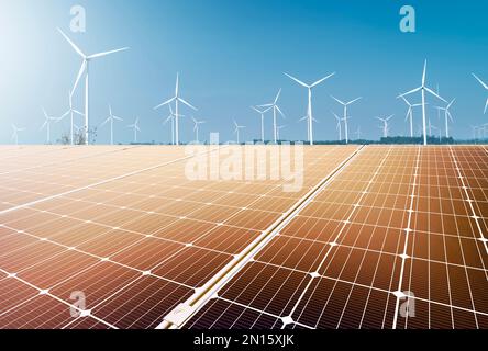 Windturbine und Sonnenkollektor bei Sonnenuntergang. Erneuerbare Energien. Erneuerbare Energien für Unternehmen. Stockfoto
