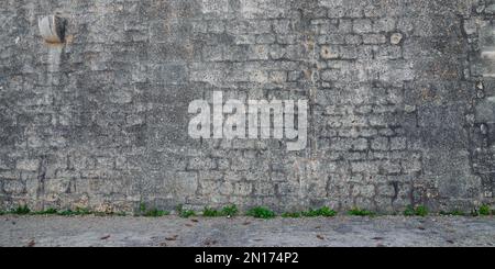 Antike graue Steinwand im Hintergrund der Stadt mit der Fassade des Hauses graue Steine Tapete Stockfoto