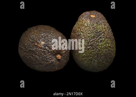 Bild von zwei reifen Avocados auf schwarzem Hintergrund Stockfoto