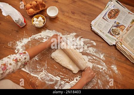 Sie macht ihr berühmtes Brotrezept. Zugeschnittene Ansicht von Händen, die mit frischem Teig auf einer Küchentheke arbeiten. Stockfoto