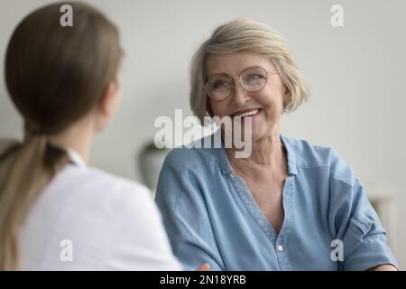 Glückliche, reife Patientin als Sprecherin in der Praxis Stockfoto