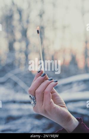 Nahaufnahme weibliche Hand mit brennendem Streichholz Konzeptfoto Stockfoto