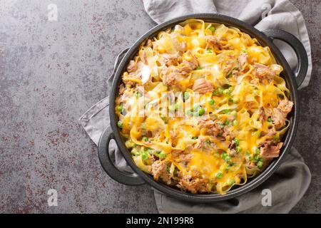 Hausgemachter Käse-Thunfisch-Auflauf mit Erbsen- und Eiernudeln auf der Pfanne auf dem Tisch. Horizontale Draufsicht von oben Stockfoto