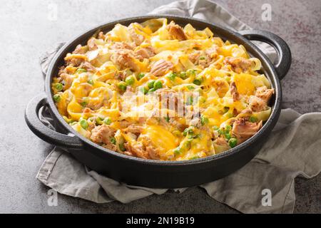 Hausgemachter Käse-Thunfisch-Auflauf mit Erbsen- und Eiernudeln auf der Pfanne auf dem Tisch. Horizontal Stockfoto