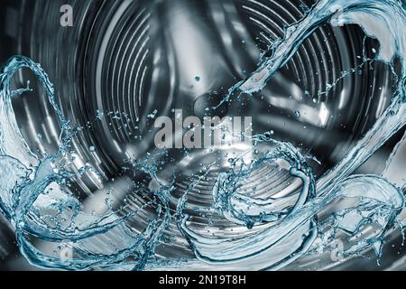 Waschmaschinentrommel mit Spritzwasser. Stockfoto