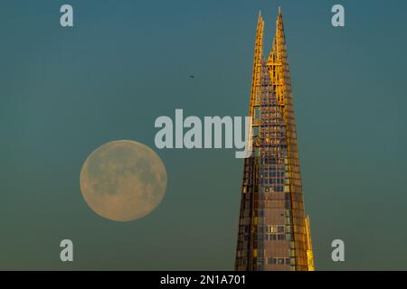 London, Großbritannien. 6. Februar 2023 UK Weather: Vollmond über dem Shard Wolkenkratzer. Auch bekannt als „Schneemond“, wird nach dem Almanach des alten Bauern ein 99,8% Mond über der Stadt während des Morgenaufgangs in westlicher nordwestlicher Richtung gesehen. Der Name „Snow Moon“ stammt von indianischen Stämmen und wurde genannt, weil im Februar Schneefall und kältere Temperaturen herrschen. Kredit: Guy Corbishley/Alamy Live News Stockfoto