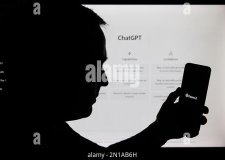 Kaunas, Lithunaia - 2022, Februar 5: Man-Silhouette mit Smartphone und ChatGPT-Logo. ChatGPT ist ein AI-Chatbot, der von OpenAI hergestellt wird. Stockfoto