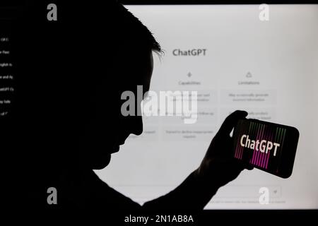 Kaunas, Lithunaia - 2022, Februar 5: Man-Silhouette mit Smartphone und ChatGPT-Logo. ChatGPT ist ein AI-Chatbot, der von OpenAI hergestellt wird. Stockfoto