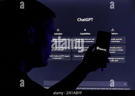 Kaunas, Lithunaia - 2022, Februar 5: Man-Silhouette mit Smartphone und ChatGPT-Logo. ChatGPT ist ein AI-Chatbot, der von OpenAI hergestellt wird. Stockfoto