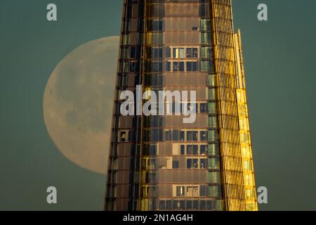 London, Großbritannien. 6. Februar 2023 UK Weather: Full Moonset in der Nähe des Shard Wolkenkratzers. Auch bekannt als „Schneemond“, wird nach dem Almanach des alten Bauern ein 99,8% Mond über der Stadt während des Morgenaufgangs in westlicher nordwestlicher Richtung gesehen. Der Name „Snow Moon“ stammt von indianischen Stämmen und wurde genannt, weil im Februar Schneefall und kältere Temperaturen herrschen. Kredit: Guy Corbishley/Alamy Live News Stockfoto