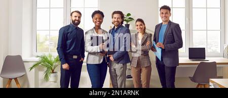 Gruppenfoto der Team-Website des Unternehmens. Kollegen stehen in ihrem eigenen modernen Büro Seite an Seite. Stockfoto