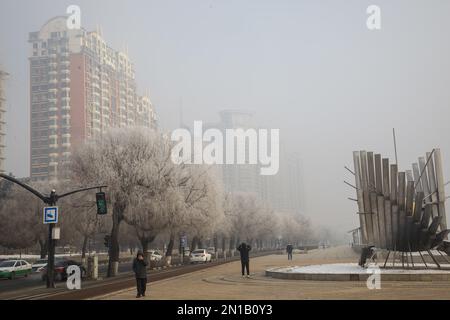 Jilin, Jilin, China. 6. Februar 2023. Am 6. Februar 2023, dem dritten Tag nach Frühling, wurde Jilin City, Provinz Jilin, Zeuge eines seltenen Naturschauspiels mit starkem Nebel, Schneeflocken, Reif und Sonnenaufgang. Gegen 9 Uhr morgens erschien plötzlich ein dichter Nebel mit einer Sicht von weniger als 50 Metern in der Stadt entlang des Songhua Flusses. Menschen, Autos und Gebäude waren vom Nebel umhüllt, der von Zeit zu Zeit verschwand und erst um mehr als 11 Uhr verschwand. Morgens schweben noch Schneeflocken am Himmel. Der Gürtel war mit Silber bedeckt, A Stockfoto