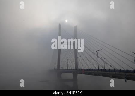 Jilin, Jilin, China. 6. Februar 2023. Am 6. Februar 2023, dem dritten Tag nach Frühling, wurde Jilin City, Provinz Jilin, Zeuge eines seltenen Naturschauspiels mit starkem Nebel, Schneeflocken, Reif und Sonnenaufgang. Gegen 9 Uhr morgens erschien plötzlich ein dichter Nebel mit einer Sicht von weniger als 50 Metern in der Stadt entlang des Songhua Flusses. Menschen, Autos und Gebäude waren vom Nebel umhüllt, der von Zeit zu Zeit verschwand und erst um mehr als 11 Uhr verschwand. Morgens schweben noch Schneeflocken am Himmel. Der Gürtel war mit Silber bedeckt, A Stockfoto