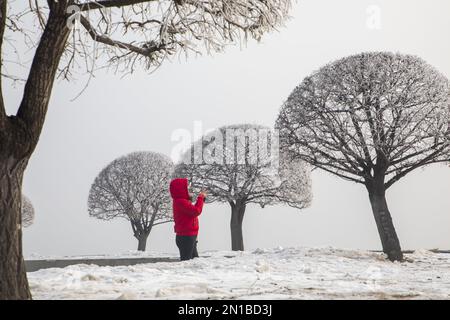 Jilin, Jilin, China. 6. Februar 2023. Am 6. Februar 2023, dem dritten Tag nach Frühling, wurde Jilin City, Provinz Jilin, Zeuge eines seltenen Naturschauspiels mit starkem Nebel, Schneeflocken, Reif und Sonnenaufgang. Gegen 9 Uhr morgens erschien plötzlich ein dichter Nebel mit einer Sicht von weniger als 50 Metern in der Stadt entlang des Songhua Flusses. Menschen, Autos und Gebäude waren vom Nebel umhüllt, der von Zeit zu Zeit verschwand und erst um mehr als 11 Uhr verschwand. Morgens schweben noch Schneeflocken am Himmel. Der Gürtel war mit Silber bedeckt, A Stockfoto