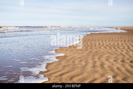 Das Wasser bedeckt langsam den Strand von Ainsdale an der Küste von Sefton. Stockfoto