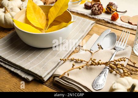 Saisonal eingerichtete Tische mit herbstlichen Blättern und anderen Herbstdekor auf Holzhintergrund Stockfoto