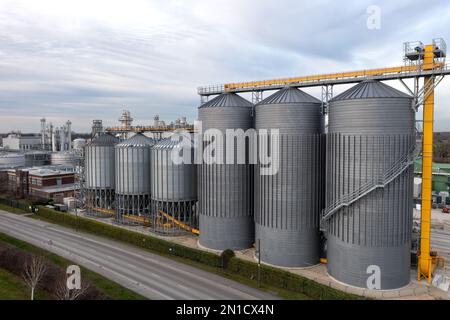 Eine Reihe großer industrieller Lagertanks oder Silos in einer Chemieanlage mit Kopierraum darüber Stockfoto