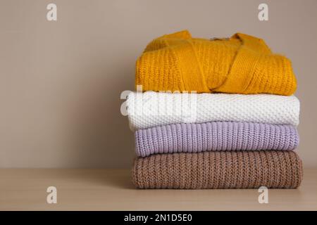 Stapel gefalteter Strickpullover auf Holztisch. Platz für Text Stockfoto