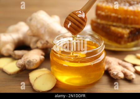 Honig und Ingwer auf Holztisch. Natürliche Heilmittel gegen Kälte Stockfoto