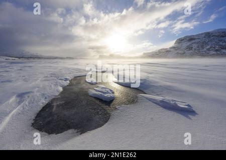 Wolken bei Sonnenuntergang über einem gefrorenen See, bedeckt mit Schnee nach einem Schneesturm, Stora Sjofallet, Norrbotten County, Lappland, Schweden, Skandinavien, Europa Stockfoto