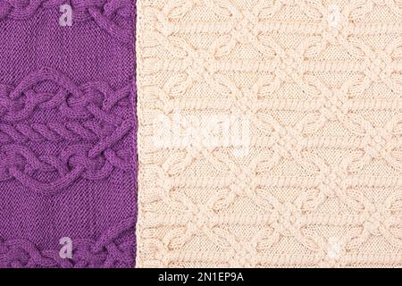 Lila- und beigefarbener Strickhintergrund. Großer Strickstoff mit Muster. Nahaufnahme einer Strickdecke. Stockfoto