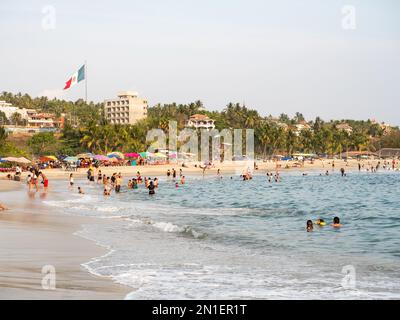 Playa Principal, der relativ ruhige Strand am kleinen Hafen von Puerto Escondido, beliebt zum Schwimmen und Essen von Meeresfrüchten, Oaxaca, Mexiko Stockfoto