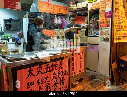 Hong Kong: Freiluft-Restaurantstand mit Speisen in Yau Ma Tei - 2022. Dezember Stockfoto