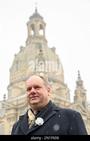 06. Februar 2023, Sachsen, Dresden: Dirk Hilbert (FDP), Oberbürgermeister von Dresden, steht vor der Frauenkirche auf dem Neumarkt-Platz vor dem Beginn der Präsentation des Posters, das am 13. Februar 2023 eine menschliche Kette fordert, und trägt eine weiße Rose auf seinem Mantel. Dresdener und zahlreiche Akteure der Zivilgesellschaft werden gemeinsam an den Bombenanschlag auf die Stadt im Jahr 1945 und die Millionen Opfer der Nazi-Tyrannei am Montag, den 13. Februar 2023, denken. In diesem Jahr jährt sich der 78. Jahrestag der Zerstörung großer Teile Dresdens. Unter dem Motto: "Frieden! Gemeinsam gestalten.“ Die menschliche Kette ist f Stockfoto