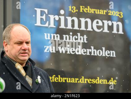 06. Februar 2023, Sachsen, Dresden: Dirk Hilbert (FDP), Oberbürgermeister von Dresden, steht am 13. Februar 2023 auf dem Neumarkt vor der Frauenkirche neben dem Plakat, auf dem eine menschliche Kette gefordert wird. Dresdener und zahlreiche Akteure der Zivilgesellschaft werden gemeinsam an den Bombenanschlag auf die Stadt im Jahr 1945 und die Millionen Opfer der nationalsozialistischen Tyrannei am Montag, den 13. Februar 2023, denken. In diesem Jahr jährt sich der 78. Jahrestag der Zerstörung großer Teile Dresdens. Unter dem Motto: "Frieden! Gemeinsam gestalten.“ Die menschliche Kette bildet sich, die - nach zwei Jahren Pandemi Stockfoto