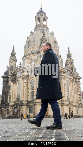 06. Februar 2023, Sachsen, Dresden: Dirk Hilbert (FDP), Oberbürgermeister der Stadt Dresden, geht am Neumarkt vor der Frauenkirche entlang, bevor am 13. Februar 2023 das Plakat mit der Forderung nach einer menschlichen Kette präsentiert wird. Dresdener und zahlreiche Akteure der Zivilgesellschaft werden am Montag, den 13. Februar 2023 zusammenkommen, um dem Bombenanschlag auf die Stadt im Jahr 1945 und den Millionen von Opfern der Nazi-Tyrannei zu gedenken. In diesem Jahr jährt sich der 78. Jahrestag der Zerstörung großer Teile Dresdens. Unter dem Motto: "Frieden! Gemeinsam gestalten.“ Die menschliche Kette wird gebildet, die - achtern Stockfoto