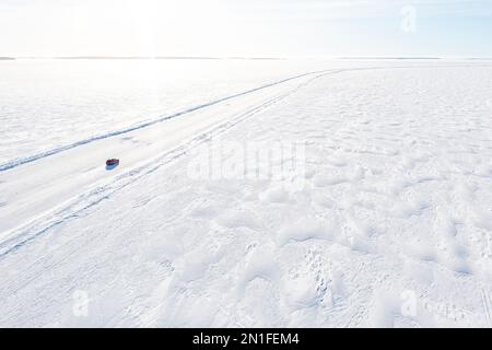 Luftaufnahme eines Autos, das auf einer rutschigen Eisstraße auf dem gefrorenen arktischen Meer, Lulea, Norrbotten County, Lappland, Schweden, Skandinavien, Europa Stockfoto