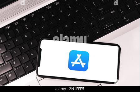Redaktioneller Hintergrund des Apple Store mit Mobilgerät und Laptop Stockfoto