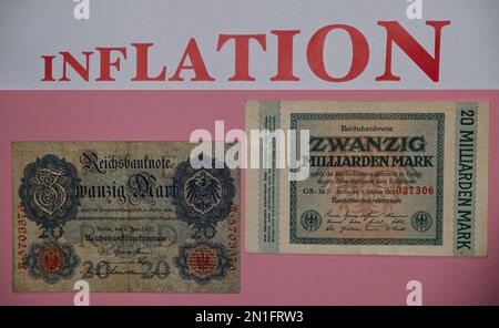 Alte deutsche-Mark-Banknoten der Weimarer Hyperinflation von 1923 mit rosa Hintergrund, Schriftzug des Wortes "INFLATION" in großen Buchstaben oben Stockfoto