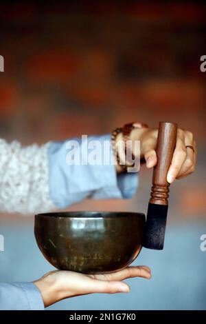 Schale in den Händen des Gebets, tibetische Gesangschüssel, buddhistisches Instrument in der Tontherapie, Meditation und Yoga, Quang Ninh, Vietnam, Indochina, Sou Stockfoto