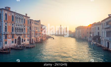 Venedig, Italien. Stadtbild des Canale Grande in Venedig, mit Basilika Santa Maria della Salute im Hintergrund bei Sonnenaufgang im Winter. Stockfoto