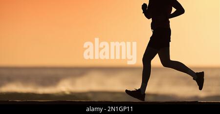 Ein guter Mann, der morgens am Meer entlang läuft. Gesunder Mann beim Joggen am Strand Stockfoto