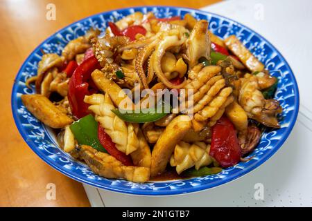 Ein köstliches chinesisches, hausgemachtes Gericht, gebratener frischer Tintenfisch mit Gemüsepaprika Stockfoto