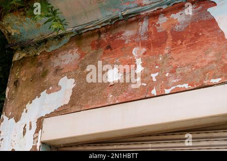 Alte schäbige Wand der Fassade eines Apartmentgebäudes mit Rissfarbe Stockfoto