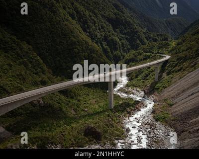 Autos, die auf der Betonbrücke Otira Viaduct über den grünen Alpental am Arthurs Pass Southern Alps Westland Westküste South Island von New Zea fahren Stockfoto