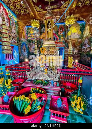 Mueang, Chiang Mai, Thailand, Innenansicht des Altars, mit Angeboten für Buddha, Dekorationen, in Phra Singh (vollständiger Name: Wat Phra Singh Woramahaviharn; Thai: วัดพระสิงห์วรมหาวิหาร; RTGS: Wat Phra Sing Wora Maha Wihan; (Aussprache); Nordthailändisch: LN-Wat Wat.hhng (thailändischer Tempist) Wat Wat Wavia Worhhha Wora Wora (thailändisch), Wawa Worhhhhhhhhar) König Ananda Mahidol (Rama VIII), verlieh ihm den Status eines königlichen Tempels der ersten Klasse im Jahr 1935. Stockfoto