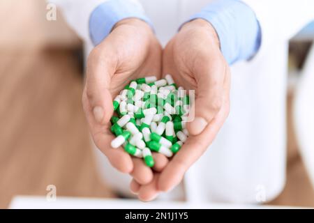 Junger hispanischer Apotheker mit Pillen in der Apotheke Stockfoto