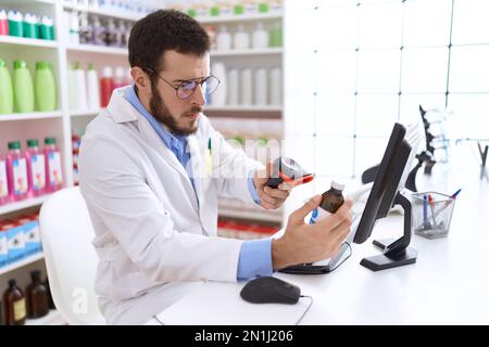 Junger hispanischer Apotheker-Scanning-Medikamentenflasche in der Apotheke Stockfoto