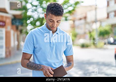 Ein afroamerikanischer Mann mit Brieftasche auf der Straße Stockfoto