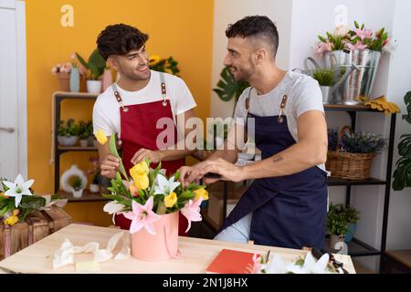 Zwei hispanische Blumenhändler, die selbstbewusst lächeln, machen einen Blumenstrauß im Blumenladen Stockfoto