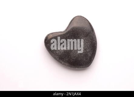 Schwarzer Stein, Herzform, Liebessymbol, Nahaufnahme des Studios, Valentinstag oder Hochzeitsgegenstand Stockfoto
