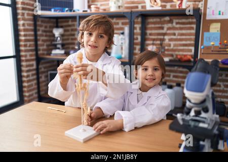 Geschwister und Geschwister, die selbstbewusst lächeln und Anatomieunterricht im Labor haben Stockfoto