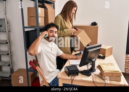 Im Büro sprechen Männer und Frauen mit dem Smartphone-Scan-Paket Stockfoto