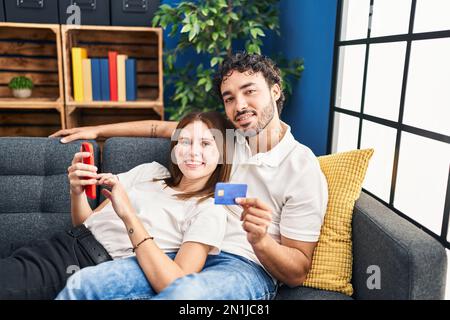 Mann und Frau verwenden Smartphone und Kreditkarte zu Hause Stockfoto